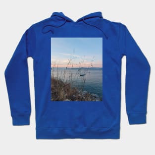 Serene Ocean Sunset: Boat Amidst Weeds Hoodie